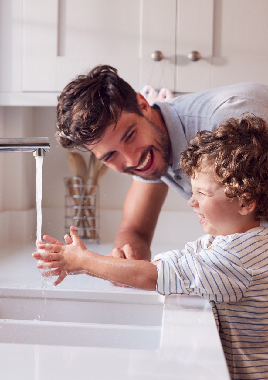Een volwassene en een kind wassen hun handen